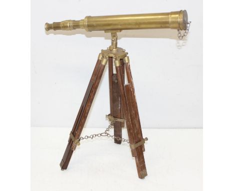 An antique style brass telescope on adjustable wooden tripod base, the telescope 45cm long