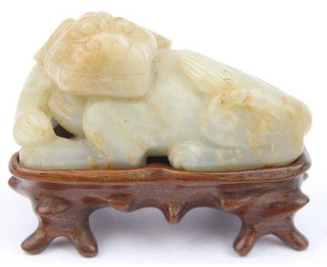 A Chinese mutton fat jade carving of a Qilin on wooden base, unknown age but likely Qing dynasty, 75mm wide