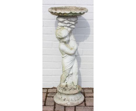 A vintage weathered concrete bird bath depicting a boy holding fish, 37cm in diameter x 93cm tall