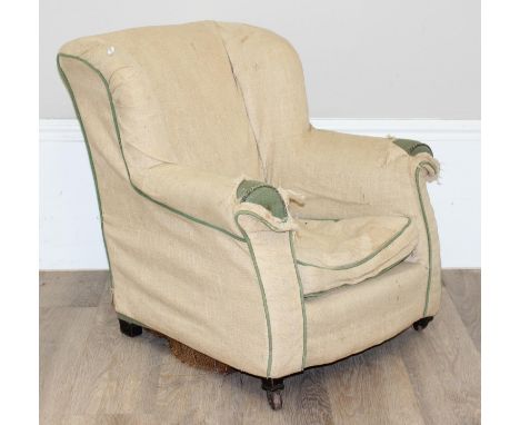A small antique child's armchair with block feet, the front with brass and ceramic castors, calico type upholstery over green
