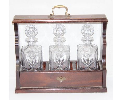 A modern 3 bottle tantalus with mahogany frame and key, 3 Scotch Whisky decanters of square form, 39cm wide
