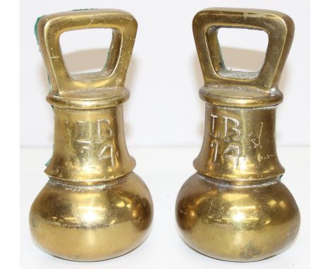 A pair of vintage brass bookends formed as a 14lb brass bell weight, each 19cm tall