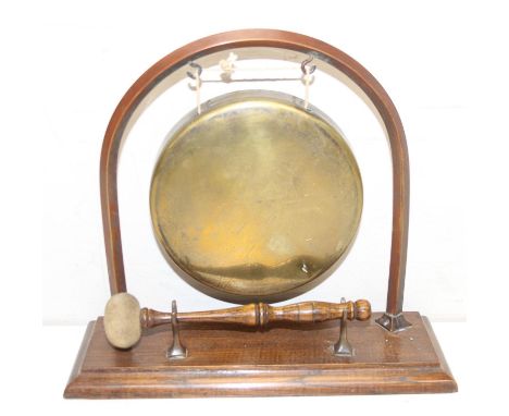 A vintage brass table gong on wooden stand, 28cm wide