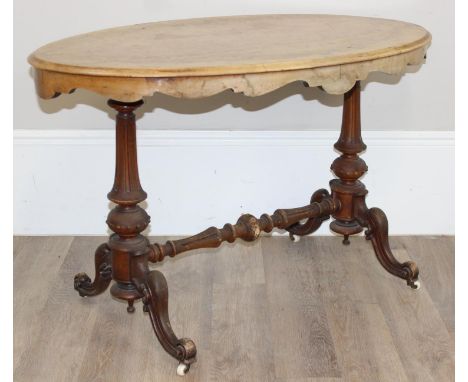 A 19th century walnut oval topped side or tea table with impressive carved base, brass and ceramic castors, Thomas Mills of B