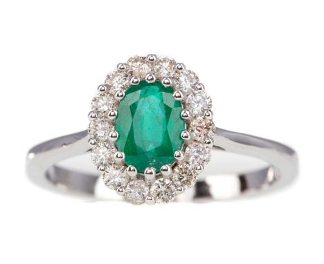 EMERALD AND DIAMOND RING,set with an oval emerald of approximately 0.70 carats, within a halo of diamonds totalling approxima