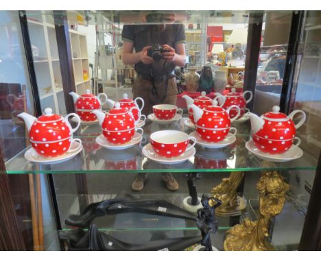 A set of four red and white polka dot ceramic tea for one sets, plus an extra tea cup and saucer 