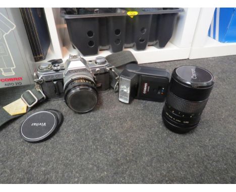 A Canon AE-1 camera in case with additional lense and Cobra Auto 210 flask 