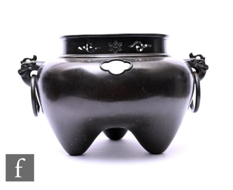 A Meiji Period Japanese bronze Furo (portable tea brazier used for ceremonies), raised on three tripod the sides flanked by m