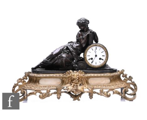 A 19th Century French bronzed spelter mantle clock modelled as a Romanesque female reclining and resting on a book, gilt meta