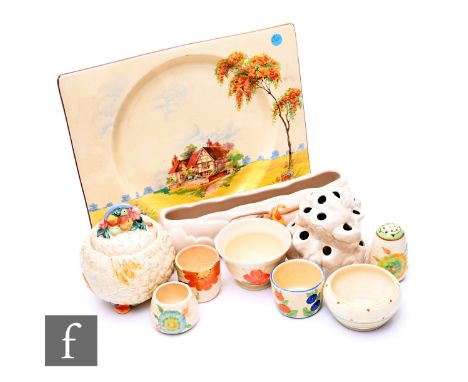 An assorted collection of Clarice Cliff and related wares to include flower trough, flower frog, preserve, eggs cups etc, in 