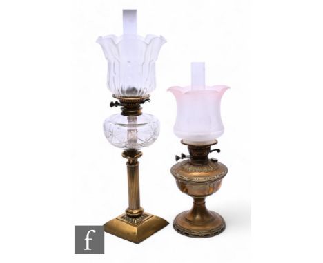 A Victorian style brass oil lamp and shade, a similar lamp and chimneys. (2)