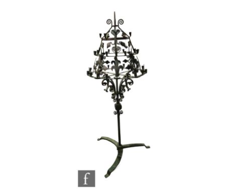 An early 20th Century wrought iron three-tier floor standing candelabra, with thirty six sconces and eight pricket sticks, al