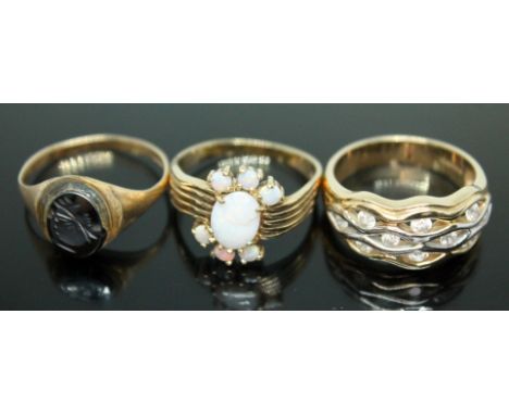 A group of three hallmarked 9ct gold rings, one set with a hematite intaglio, one set with precious opals and another with co