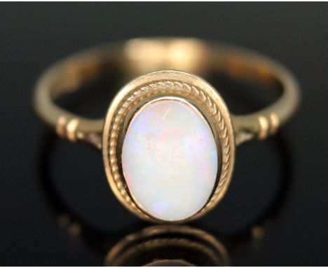 A hallmarked 9ct gold ring set with an oval precious opal cabochon, gross weight 1.66g, size O.  Condition - good, no damage/