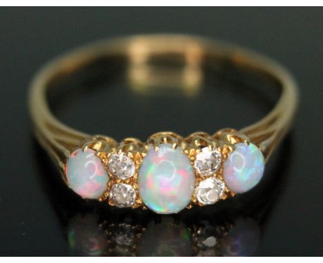 An early 20th century precious opal and diamond ring, the central oval cabochon measuring approx. 5mm x 3mm, total approx. di