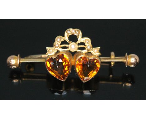 An Edwardian citrine and split pearl brooch, the two heart shaped cut orange citrines measuring approx. 8mm x 7mm x 3mm, yell