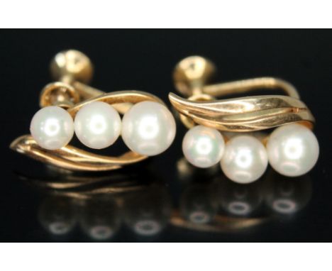 A pair of Mikimoto cultured pearl earrings, each elipipse shapded earring set with three graduated pearls ranging in diameter