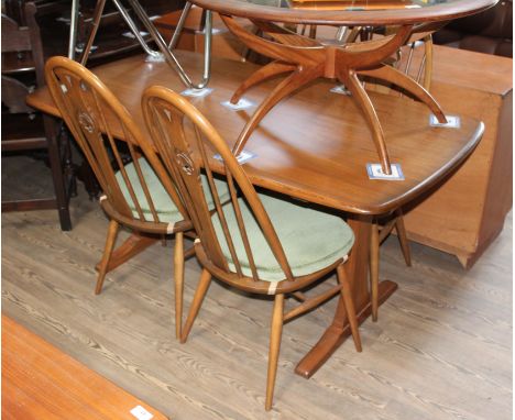 An Ercol refectory table and four swan back chairs.The upholstery may not comply with the Furniture and Furnishings (Fire) Re