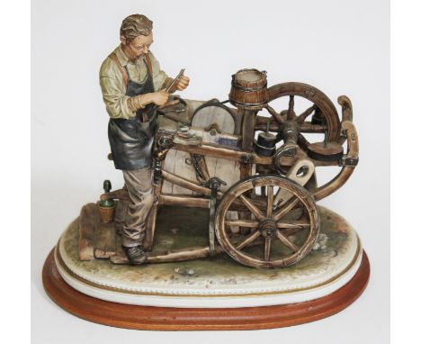A large Capodimonte figure group "The knife grinder with Cart", signed Sandro Maggioni, 1979, on wooden plinth, height 31cm. 