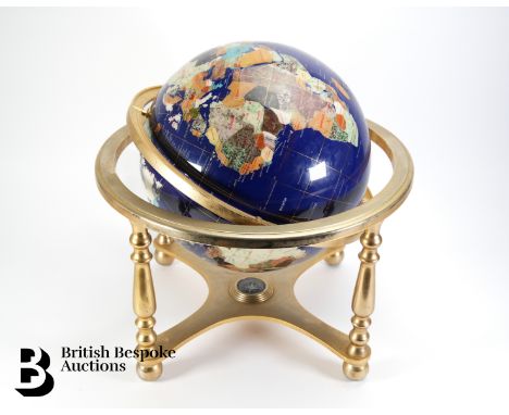 A large blue lapis lazuli table top gemstone world globe, supported on a brass four-footed base with an x-frame stretcher set