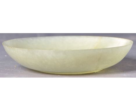 A 19th Century Chinese carved mutton fat jade dish of shallow circular form having a small circular base and being carved wit