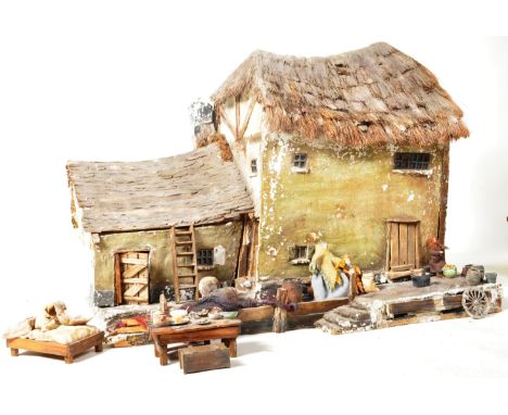 A 19th Century plaster and wood model of a fisherman's cottage / house. Features a two storey cottage building with thatched 