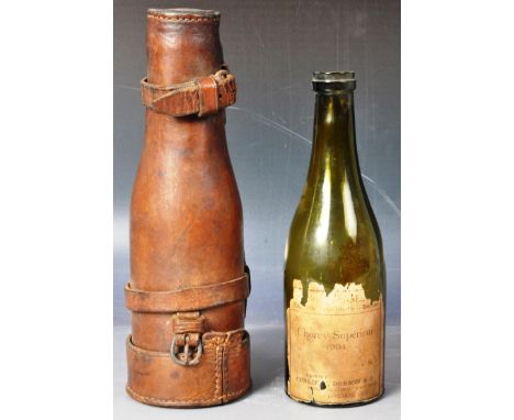 An early 20th Century leather hunting flask of typical form. The case containing a glass wine bottle with label for Shorey Su