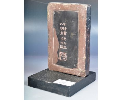 A 20th Century Chinese hand carved slate block having two rows of Kaishu script with seal mark underneath, The slate having a