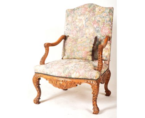 A 19th Century carved walnut throne chair armchair having a tall upright shield back with shaped scroll &amp; carved elbow ar