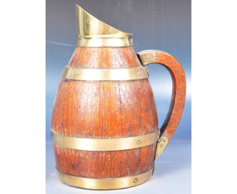 An early 19th Century George III wooden treen ale pitcher jug of coopered barrel form. Oak construction with brass bound and 