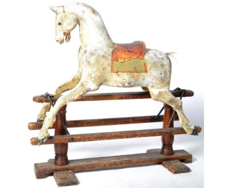 A Victorian wooden painted rocking horse. Depicting a dapple grey horse with inset glass bead eyes, horse hair tail &amp; lea