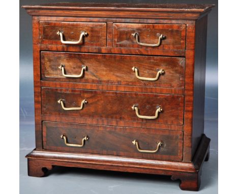 An early 19th Century walnut miniature chest / salesman's sample or apprentice piece. The bank of drawers having quarter pane