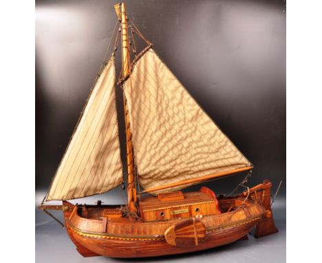 An early 20th Century Dutch handmade scratch built model boat ship having a single mast with two sails, detailed deck with ca