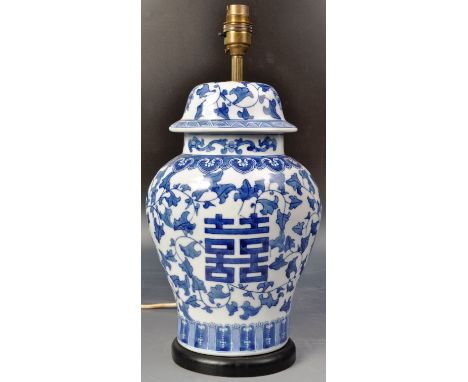 A 20th century Chinese blue and white porcelain vase / lamp having hand painted decoration depicting scrolling leaves and fea