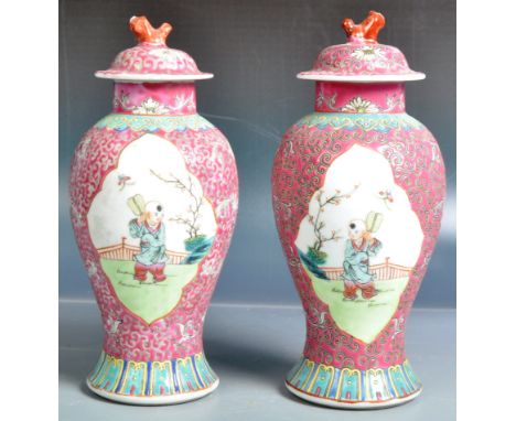 A pair of 20th Century Chinese porcelain vases and covers. Both decorated in the scrolling leaves pattern with white cartouch