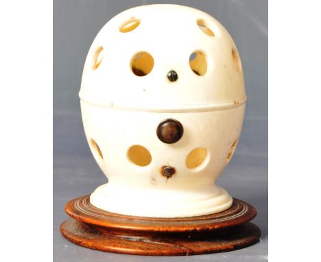 A most unusual 18th Century ivory toy of ovoid shape having a hinged lid with button clasp having multiple holes raised on a 