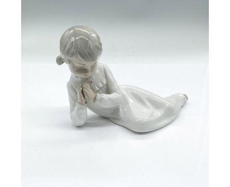 A lying young girl up on one elbow praying. Gloss finish. NAO by Lladro backstamp. Issued: 20th centuryDimensions: 7.5"L x 3"