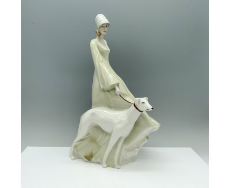 A porcelain figurine featuring a graceful woman adorned in a captivating misty green dress, complemented by a charming blue h