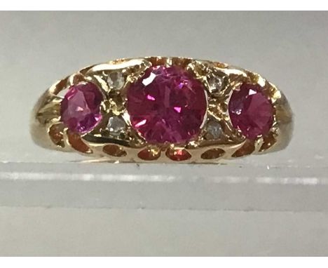 EDWARDIAN EIGHTEEN CARAT GOLD RING set with red stones and diamond chips