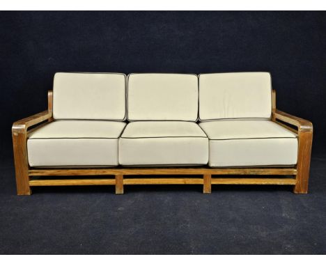 An Art Deco style teak garden or conservatory sofa, with piped white upholstery. H.96 W.230 D.95cm. 