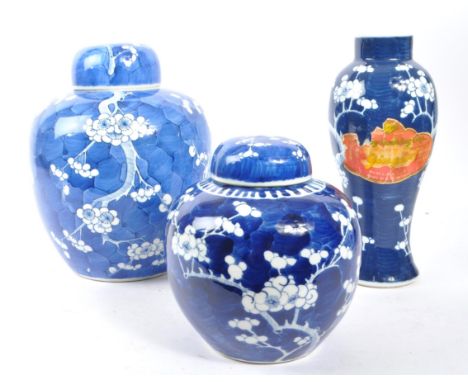 Two large Chinese oriental blue and white porcelain ginger jars with lids accompanied by a vase, all having Prunus pattern. E