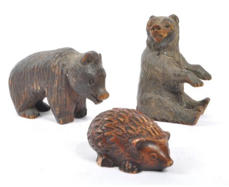 Two vintage 20th Century Black Forest hand carved wooden bears, one stood on all fours, the other sitting up with arms forwar