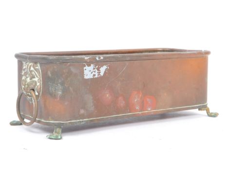 A 19th Century Victorian copper trough / planter of rectangular form with brass lions head ring handles upon four brass claw 