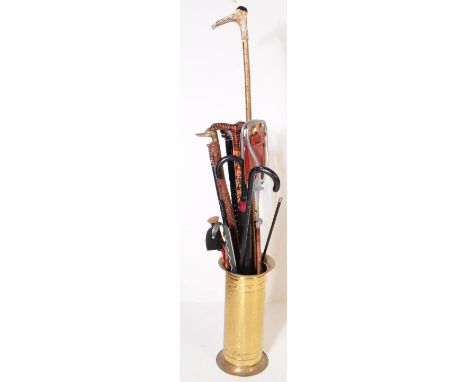 A vintage 20th century brass Indian stick / walking stick stand. With a collection of swagger stick / canes. To include brass