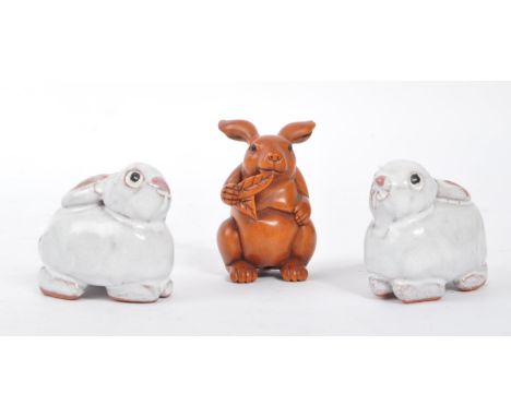 A vintage 20th century Netsuke rabbits sculpture / figures. To include two ceramic examples, and a wooden carved piece. Havin