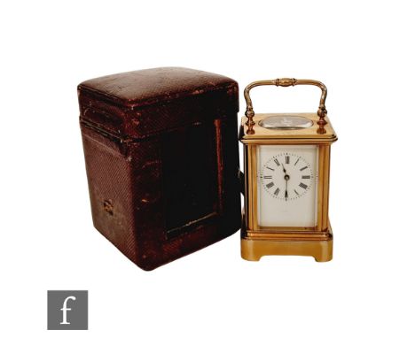 A late 19th Century miniature French brass carriage clock, bevelled glass case on bracket plinth, height 7cm, in red leather 