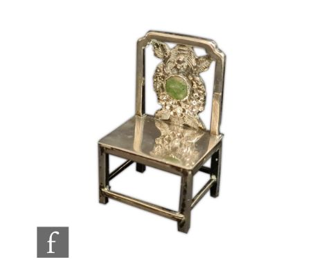 An early 20th Century Chinese silver miniature Hongmu chair, applied with a green hardstone roundel to the splat, height 5cm,