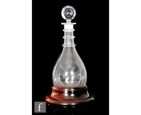 An 18th Century round bottomed decanter of tapering form, circa 1780, with three ringed neck and target form stopper, resting