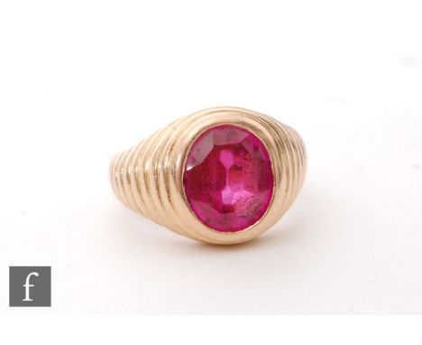 An 18ct gentleman's ring set with a collar set red paste stone to ribbed shoulders, weight 10g, ring size M. 