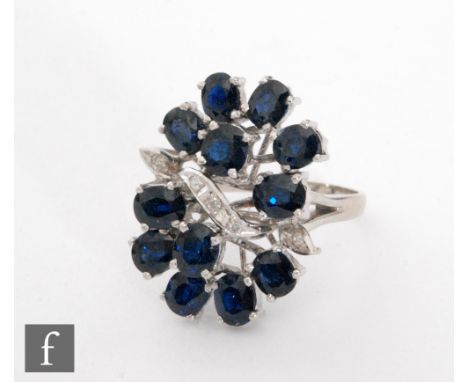 An 18ct white gold sapphire and diamond cluster ring, five diamonds horizontally set flanked by six claw set individually set